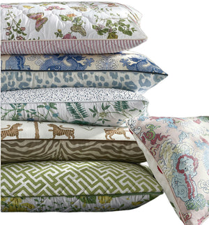 The Reversible Lumbar Pillow Collection by Matouk features six pillows with colorful patterns—florals, animals, prints, geometrics, and abstracts—some accented with piped edges and hidden zippers for a polished touch.