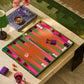 The Addison Ross Lacquer Backgammon Collection is displayed with pieces, dice, and cups on a coffee table beside snacks, a drink, and a lamp in a cozy living room.