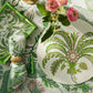 A chic Palm Beach table setting featuring Addison Ross's Palm Beach Scallop Tray Collection in green and pink florals, paired with a plate, napkin, fork, and a pink-white bouquet on a matching cloth for stylish décor flair.