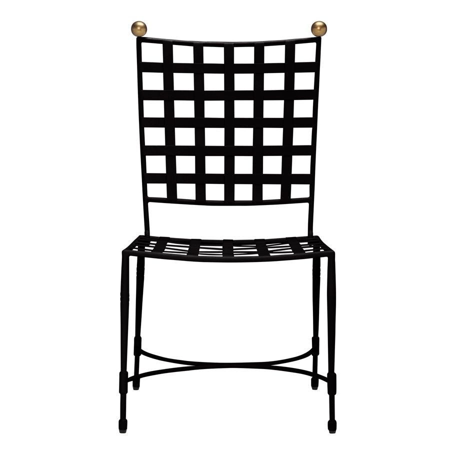 The Amalfi Dining Side Chair in Slate by Janus et Cie features a black metal frame with a square grid backrest and seat, gold sphere finials, and offers an elegant stainless steel outdoor seating option inspired by the iconic Amalfi line.