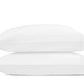 Two white pillows from the Matouk Amara Triple Pearl Bedding Collection, featuring stitched edges, are stacked atop one another against a plain white background, their surfaces adorned with a subtle Triple Pearl sateen embroidery that lends an elegant touch.