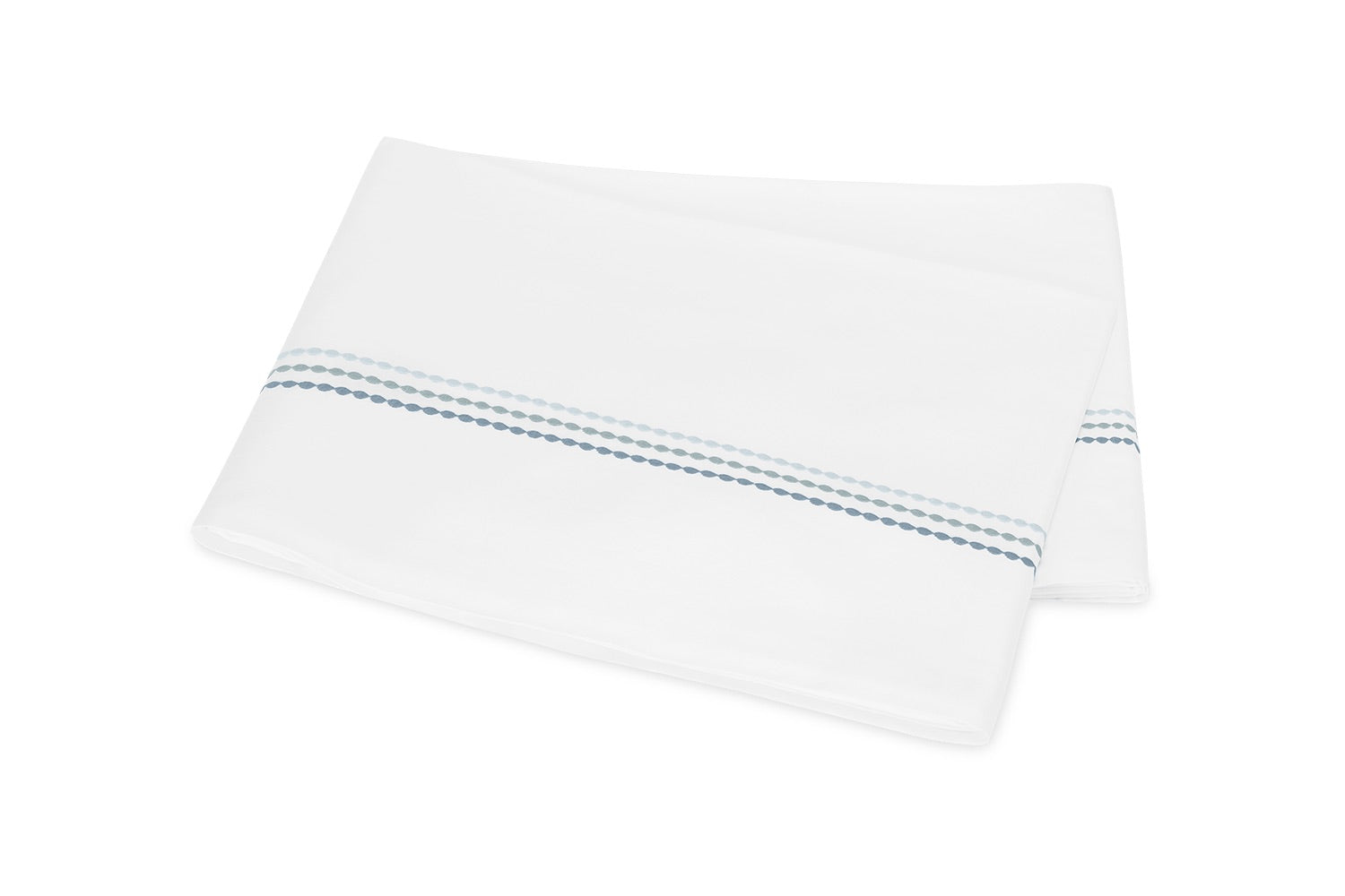 Displayed on a plain white background, the folded white bedsheet from the Matouk Amara Triple Pearl Bedding Collection features an elegant embroidered design of two parallel dotted blue lines near the edge and is crafted from luxurious Amara sateen.