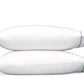 Two pillows from the Matouk Ansonia Bedding Collection are stacked on top of each other, each featuring a green stripe with elegant satin stitching near the edge, set against a plain white background.