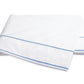 The Matouk Ansonia Bedding Collection features a folded white bed sheet crafted from soft cotton percale, accented by two parallel light blue lines near the edge finished in elegant satin stitching, displayed on a plain background—a perfect touch of luxury bedding for any refined space.