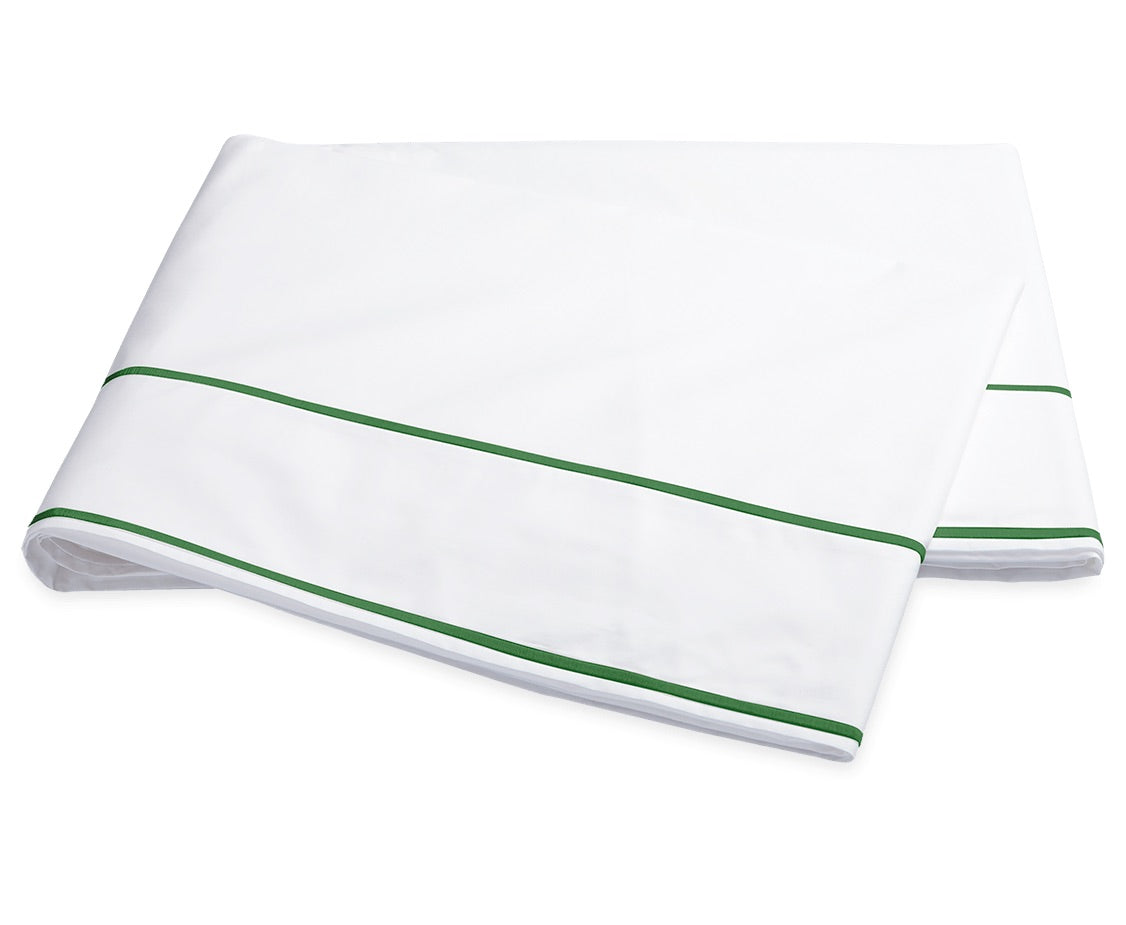 A folded sheet from the Ansonia Bedding Collection by Matouk, crafted from smooth cotton percale and featuring two parallel green stripes near the edge, is displayed on a plain white background.