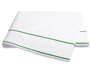 A folded sheet from the Ansonia Bedding Collection by Matouk, crafted from smooth cotton percale and featuring two parallel green stripes near the edge, is displayed on a plain white background.