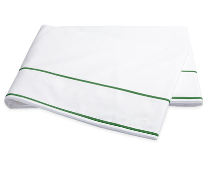 A folded sheet from the Ansonia Bedding Collection by Matouk, crafted from smooth cotton percale and featuring two parallel green stripes near the edge, is displayed on a plain white background.