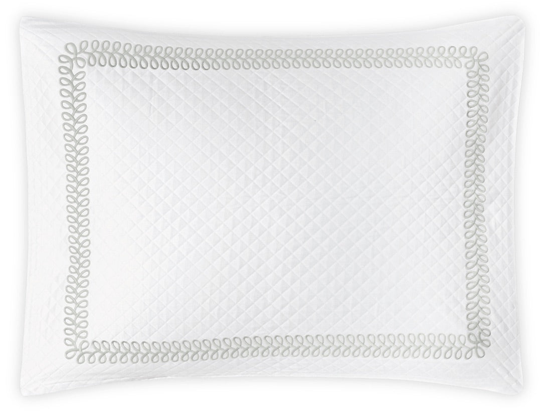 Crafted by Matouk, the Astor Braid Matelassé Bedding Collection features a white quilted pillowcase with an elegant diamond matelassé pattern and a decorative gray loop border inspired by the signature Astor Braid embroidery.