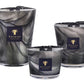 The Baobab Atlas Toubkal Collection includes three candles in different sizes, each showcasing gray and black marbled glass with branded labels, all infused with the delicate aroma of Atlas cedar.