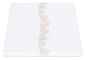 Matouk Atoll Bedding Collection, Dune napkin made of Ceylon cotton percale, with a delicate, coral branch embroidered pattern in pale orange, positioned vertically in the center.