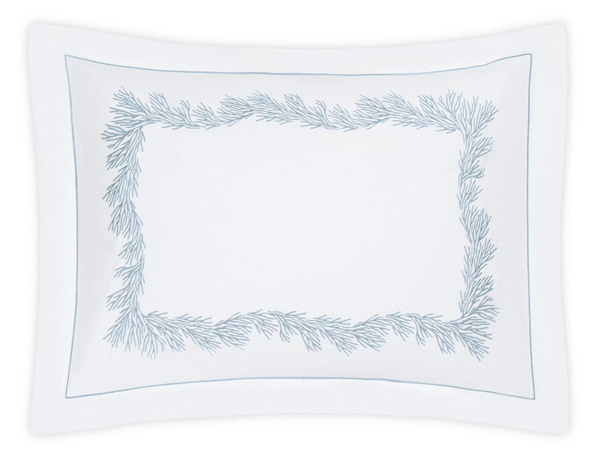 The Atoll Bedding Collection by Matouk for Wedgwood features a white pillowcase crafted from soft Ceylon cotton percale, with a rectangular satin stitch border and light blue, branch-like embroidery around the center.
