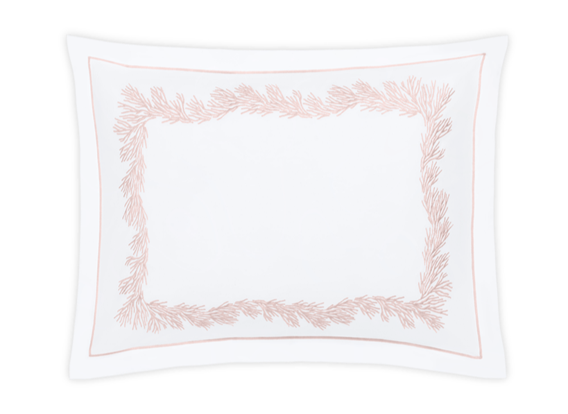 The Matouk Atoll Bedding Collection in Blush features a white rectangular pillowcase with a light pink feathery coral botanical border, crafted from soft Ceylon cotton percale.