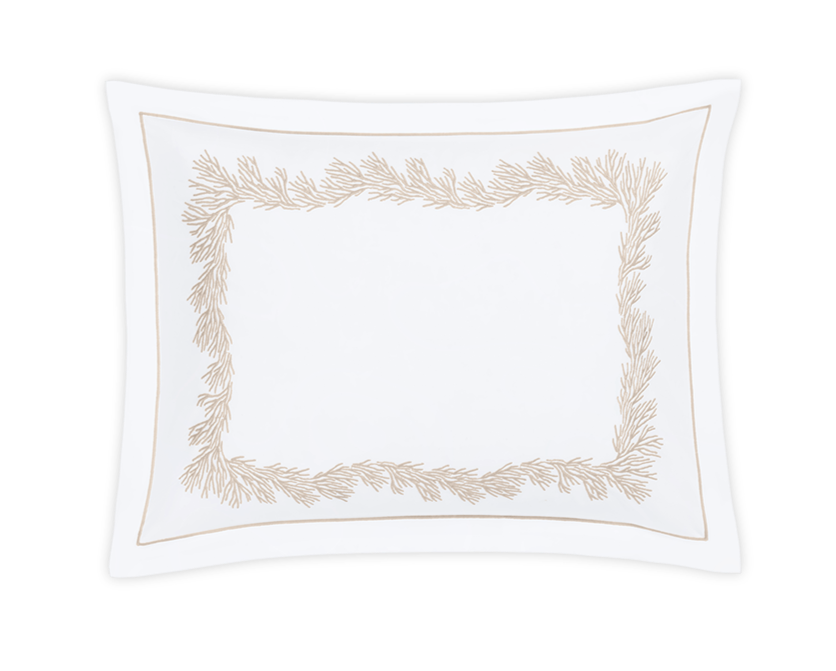 The Atoll Bedding Collection, Dune by Matouk features a white rectangular pillowcase crafted from Ceylon cotton percale (520 thread count) with beige leaf embroidery along the border, set against a plain black background.