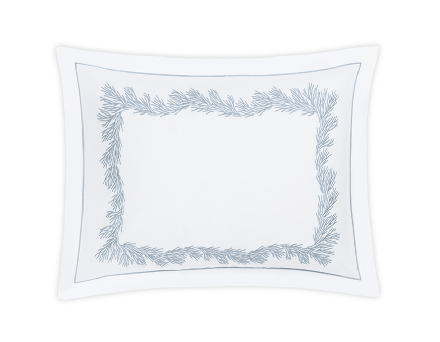 The Atoll Bedding Collection by Matouk for Wedgwood features a white rectangular pillowcase with blue pine branch embroidery on the satin stitch border, crafted from soft Ceylon cotton percale, shown against a plain black background.