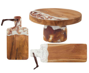 The Blue Pheasant Austin Swirled Serveware Collection includes three handcrafted wooden boards and a cake stand, each with white and brown marbled resin accents; two boards have leather straps.