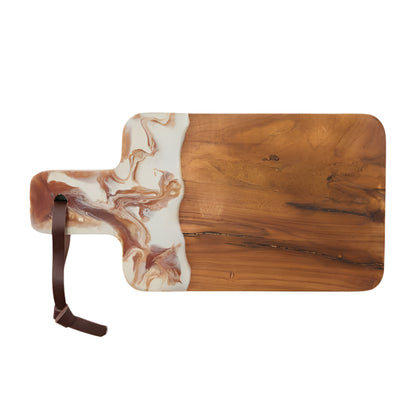 The Austin Swirled Serveware Collection by Blue Pheasant features a handcrafted rectangular teak cutting board with a marbled resin accent and a leather loop on the handle.
