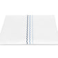 Displayed on a plain white background, the Axel Bedding Collection sheet by Matouk features three vertical wavy lines in blue and navy zigzag embroidery along one edge.