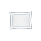 The Axel Bedding Collection by Matouk showcases a white pillow accented with a blue scalloped border and inner outline, featuring delicate zigzag embroidery at the center—a refined touch that elevates any modern bed.