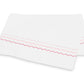 Two white rectangular cloths from the Axel Bedding Collection by Matouk, crafted from luxurious long-staple cotton, feature pink and red zigzag embroidery along one edge and are stacked slightly askew on a white background.