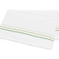 Two folded white pillowcases from the Axel Bedding Collection by Matouk, featuring green zigzag embroidery along one edge, crafted from luxurious long-staple cotton—a crisp, modern bed essential.