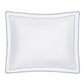 Introducing the Axel Bedding Collection by Matouk: a white rectangular pillowcase made from luxurious long-staple cotton, adorned with a scalloped edge and double line of blue zigzag embroidery near the border—a refined detail that elevates any modern bed.