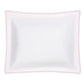 The Axel Bedding Collection by Matouk features a white rectangular pillow with scalloped edges and pink zigzag embroidery trim, crafted from soft long-staple cotton and photographed on a plain white background—an elegant accent for any modern bed.
