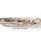 The Mocha Resin Serveware Collection by Nashi Home features a medium oval boat bowl with a marbled mix of gray, cream, and brown. Crafted from food-safe resin, it adds style to your home decor. Text on image: "Boat Bowl Medium.