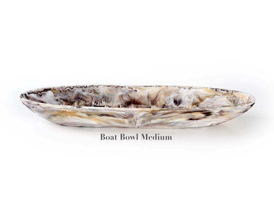 The Mocha Resin Serveware Collection by Nashi Home features a medium oval boat bowl with a marbled mix of gray, cream, and brown. Crafted from food-safe resin, it adds style to your home decor. Text on image: "Boat Bowl Medium.
