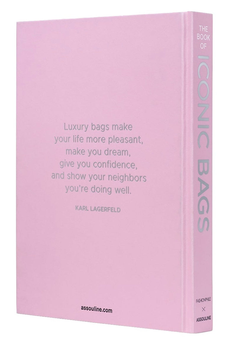 A pink hardcover book, "Fashionphile: The Book of Iconic Bags" by Assouline, features a Karl Lagerfeld quote on luxury accessories and investment handbags on the front cover.