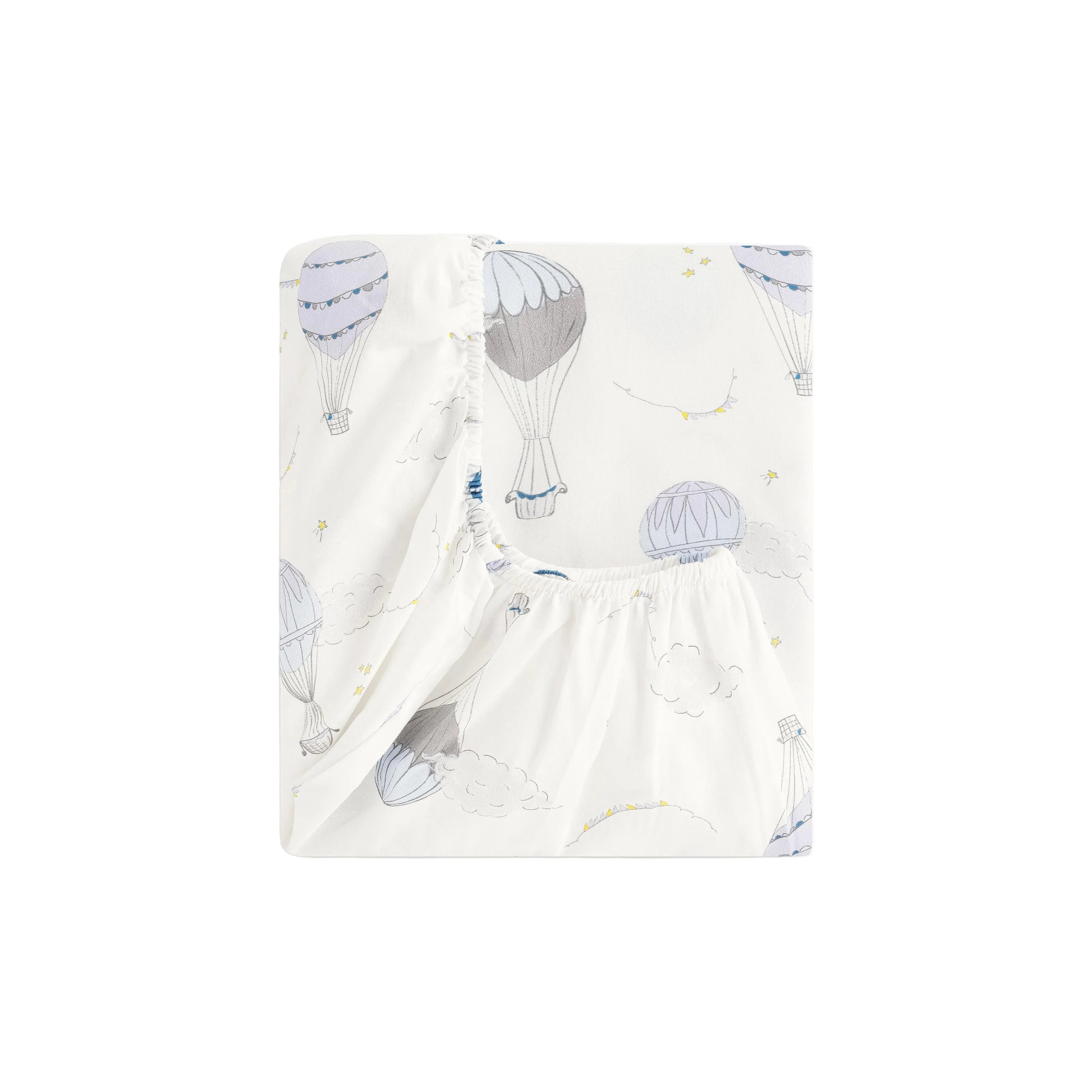 The Gooselings Touch the Sky Bedding Collection features a white fitted sheet adorned with pastel hot air balloons, clouds, and birds, crafted from pure materials and neatly folded against a plain white background.