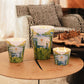 Three Baobab Collection Sacred Trees Summer Yarani patterned candles of different sizes rest on a round wooden table. A chessboard is set against patterned furniture, creating the mystique of a baobab forest.