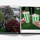 An open copy of Assouline’s "Baur Au Lac: A Legacy by the Lake" displays an outdoor movie screening in Zurich on the left page, while two hands holding green striped popcorn containers are pictured on the right page.