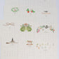 Twelve monthly Karen Adams 2027 Classic Desk Calendar cards, each featuring unique seasonal illustrations above the dates.