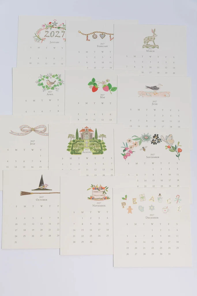 Twelve monthly Karen Adams 2027 Classic Desk Calendar cards, each featuring unique seasonal illustrations above the dates.