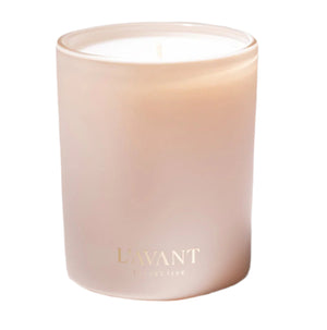 The Blushed Bergamot Candle by L'Avant Collective features a frosted glass vessel, white wax, and gold branding on the front. This luxurious candle is crafted from a soy and coconut blend with an elegant scent.