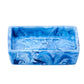 Nashi Home’s Denim Resin Bath Collection features a rectangular, blue marbled soap dish with a glossy finish inspired by Sydney beaches, shown against a white background.