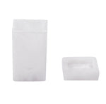 The Nashi Home Bath Collection in Swirl White features two white objects: a tall, standing container and a flat, square dish with rounded edges. Their translucent design, evoking resin collections, captures the serene beauty of Sydney beaches.