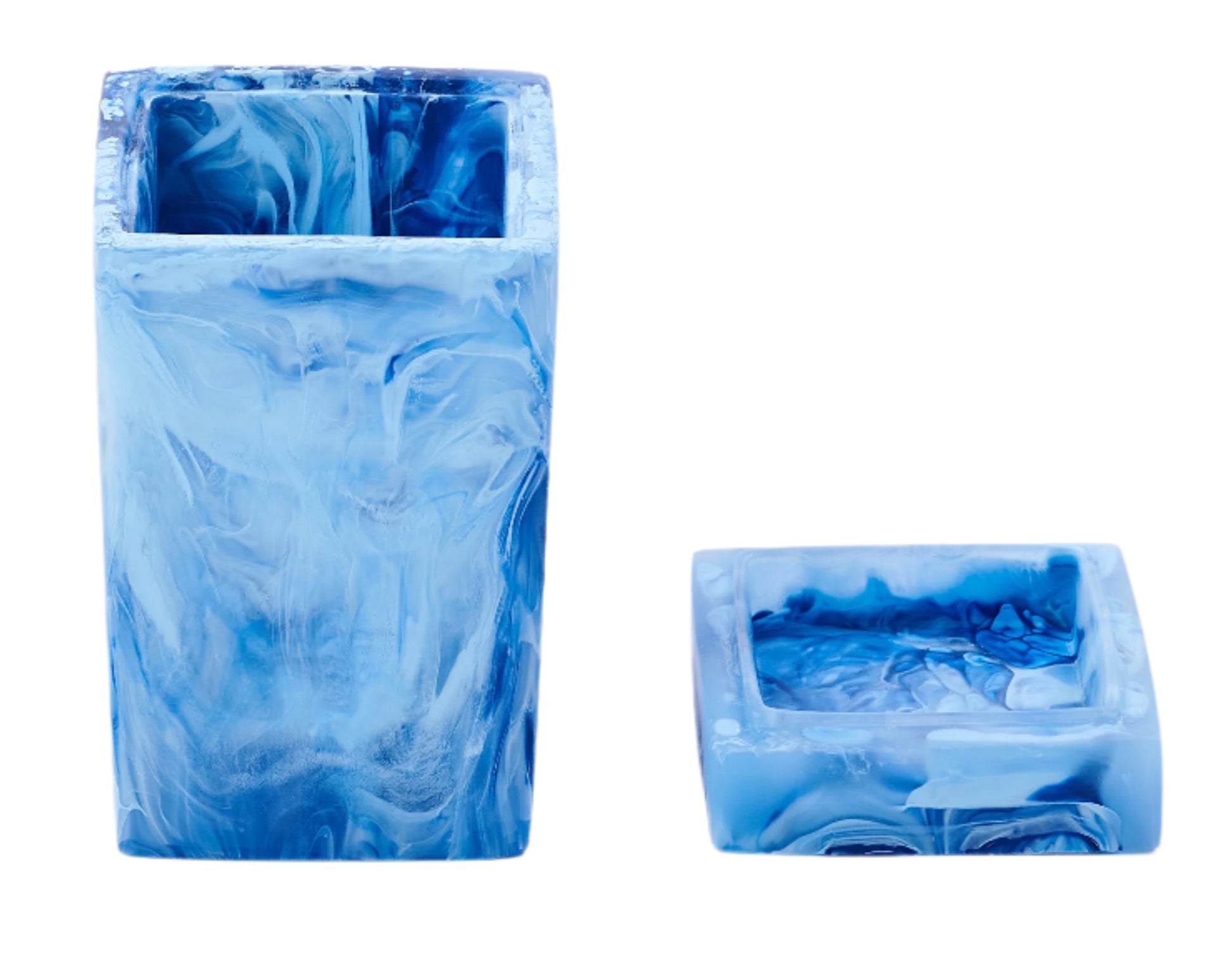 Two blue, marbled square resin containers from Nashi Home’s Denim Resin Bath Collection are displayed—one upright and tall, the other short and on its side—perfect additions to any modern bathroom.