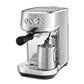 The Breville Bambino Plus Espresso Machine with ThermoJet heating expertly steams milk in a metal pitcher using its steam wand—ideal for making specialty coffee drinks.