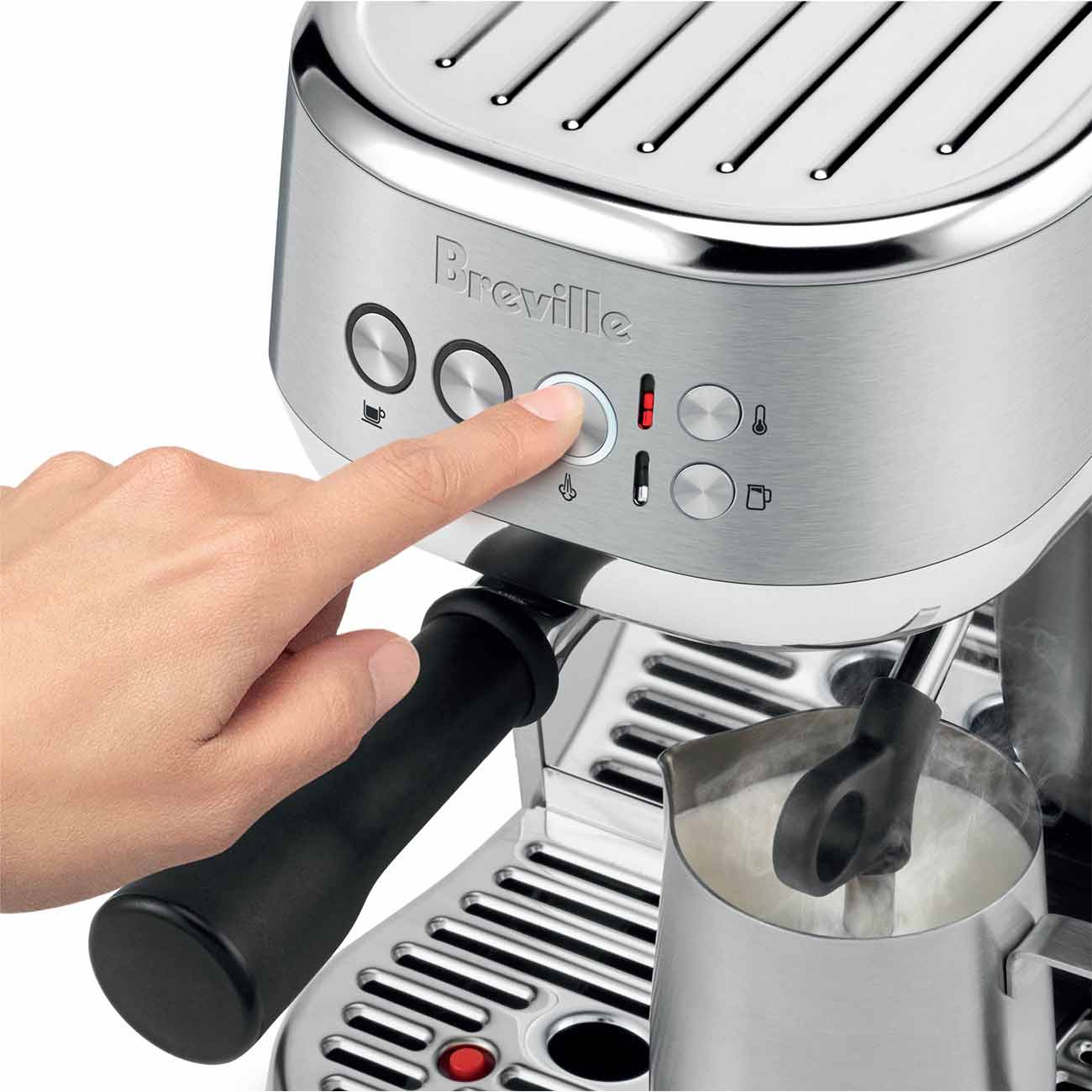 A hand presses a button on the Breville Bambino Plus Espresso Machine, featuring a ThermoJet heating system, as the automatic steam wand froths milk in a metal pitcher—ideal for crafting specialty coffee at home.