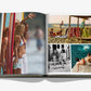 An open issue of Assouline’s "Biarritz Basque" reveals a collection of stunning beach-themed photographs, highlighting surfers with boards in Biarritz, beach chairs by the ocean, two people on steps, and two individuals by a natural pool in the Basque Country.