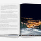An open book displays a text page on the left and, on the right, a nighttime photo of Big Sky Resort in Montana nestled in snowy mountains, featured in "Big Sky" by Assouline.