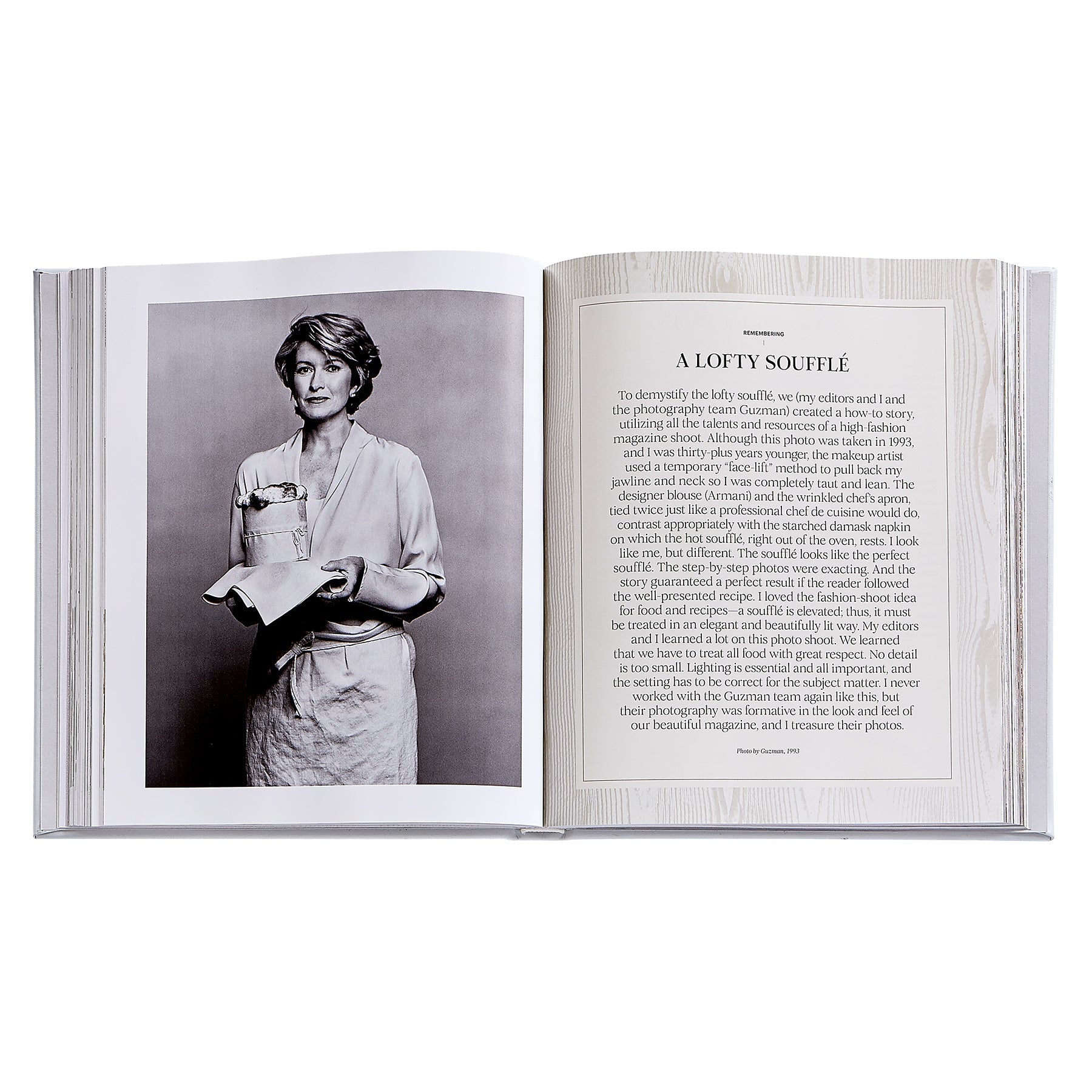 The Leather Bound "Martha: The Cookbook" by Graphic Image lies open, featuring a black-and-white photo of a woman with a soufflé on one page and the "A Lofty Soufflé" recipe on the other, inspiring your next favorite dish.