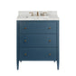 The Conrad Vanity Collection by Made Goods features a blue faux raffia bathroom vanity with three soft-close drawers, gold knobs, a marble countertop, and a brass faucet, shown against a white background.