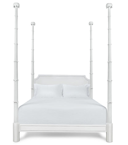 The Keller Bed by Bunny Williams features tall, sculpted four posts, a rectangular headboard, and white bedding, beautifully photographed against a plain white background.