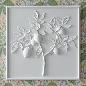 The Bunny Williams Lemon Plaster Panel features a white, three-dimensional relief of a lemon tree branch with leaves and fruit, elegantly framed to create sophisticated wall decor.