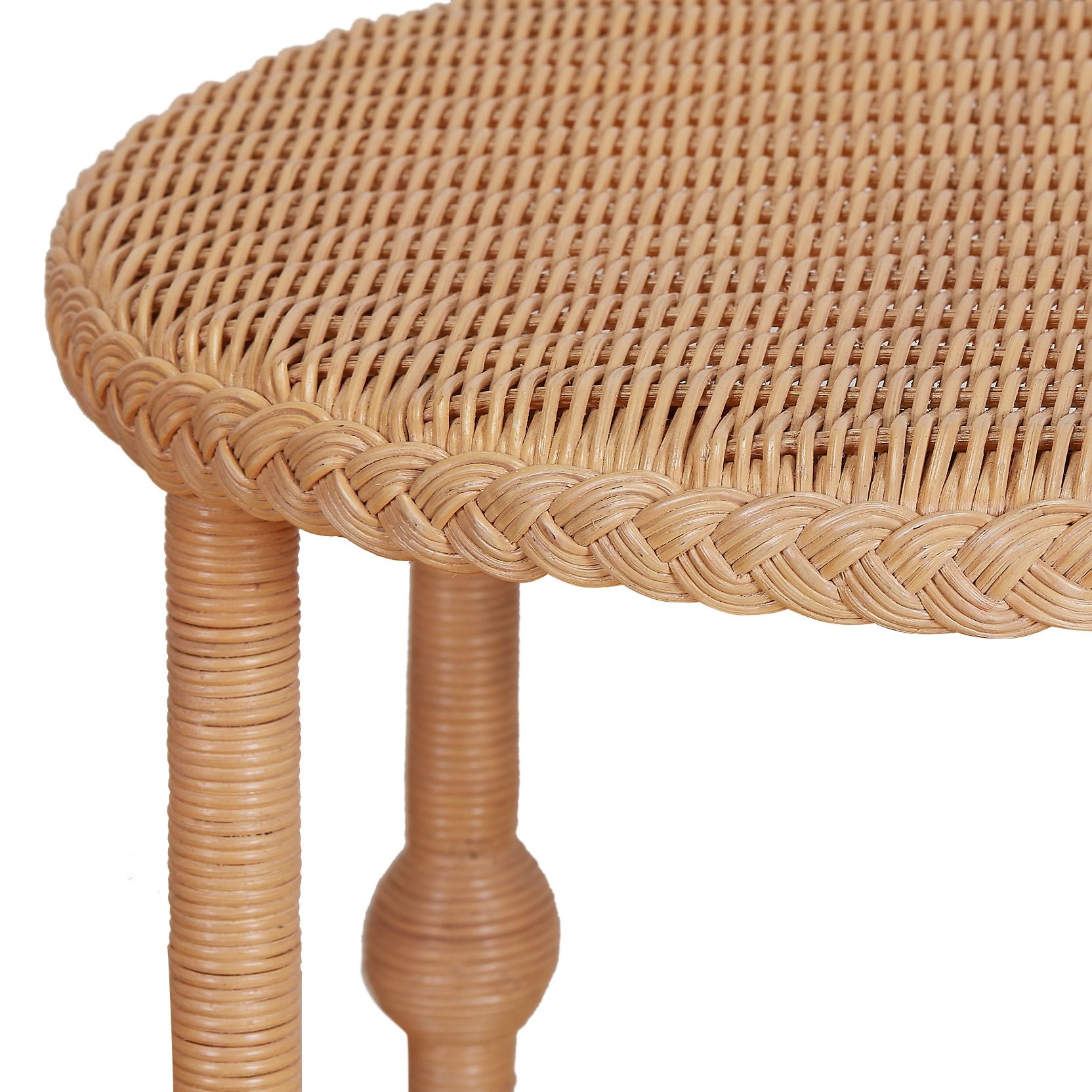 A close-up of the Bunny Williams Lucas Drinks Table, featuring a roomy round wicker top with braided edge and cylindrical wicker legs.