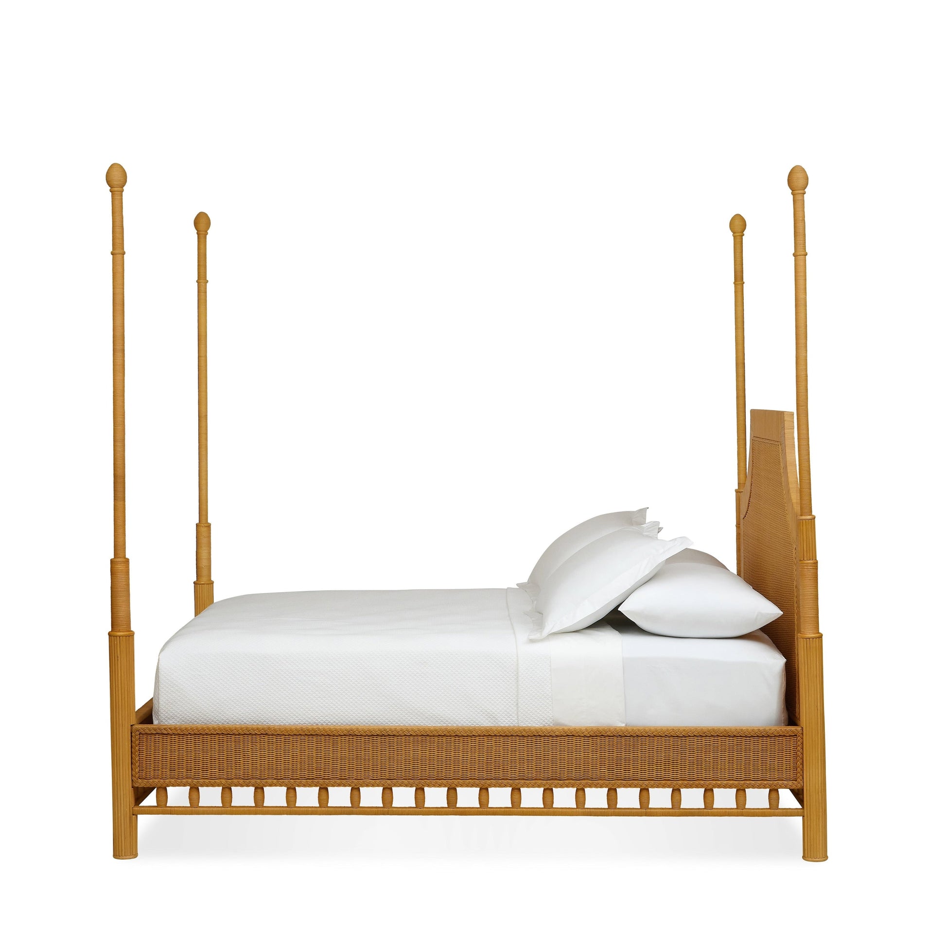 The Bunny Williams Rattan Trellis Canopy Bed, featuring a rectangular headboard with a subtle lattice design, is shown from the side against a white background and dressed in white bedding and pillows.