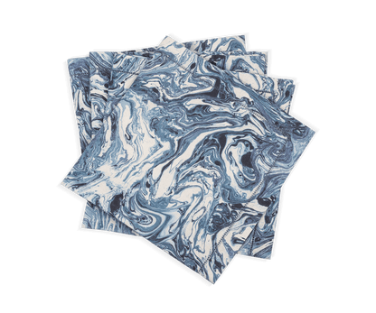 A set of four Balthazar Napkins by Matouk, featuring a striking blue and white marbled pattern, are stacked unevenly against a white background—bringing an elegant and sophisticated touch to your table setting for any occasion.