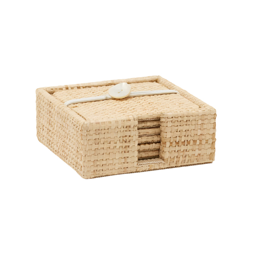 Blue Pheasant Barth Natural Raffia Coasters come in a square woven rattan box with a lid, closed by a white button and loop. Matching coasters peek through a side opening—a stylish patio accent from Blue Pheasant’s Barth collection.